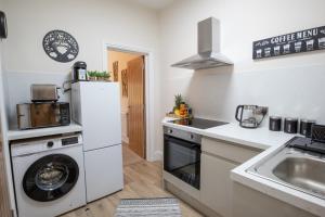 una cucina con lavatrice e lavandino di Family Apartment, Close to Town and Beach a Eastbourne