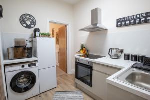 a kitchen with a washing machine and a sink at Cosy, Modern One Bedroom Apartment, Close to Train, City, Beach and Hospital Long Booking Welcome in Eastbourne