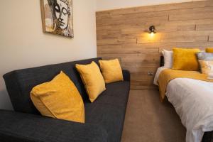 um quarto com um sofá e uma cama com almofadas amarelas em Family Apartment, Close to Town and Beach em Eastbourne