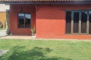 a red house with a potted plant in front of it at Casa-huate Malinalco zona centro ¡disfruta! in Malinalco