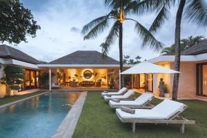 a villa with a swimming pool and lounge chairs at Villa Alabali in Seminyak