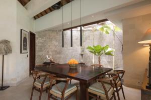 a dining room with a wooden table and chairs at Villa Alabali in Seminyak