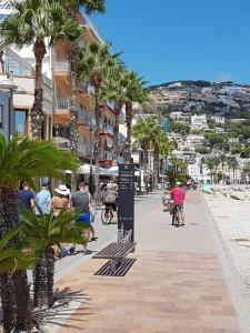 a group of people riding bikes down a street with palm trees at Javea Park 6-32 in Jávea