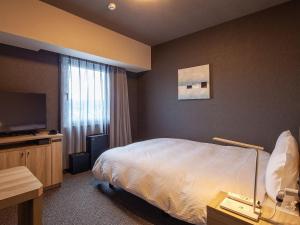 Postel nebo postele na pokoji v ubytování Hotel Route Inn Miyoshi Ekimae