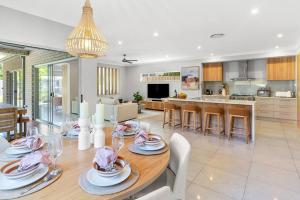 comedor y cocina con mesa y sillas en Burleigh Getaway en Gold Coast