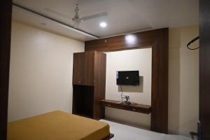 a bedroom with a bed and a flat screen tv at RS GUEST HOUSE in Nagpur