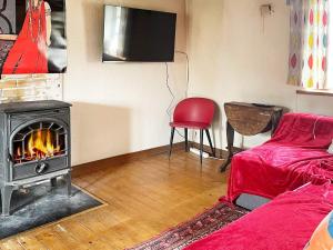un soggiorno con camino e sedia rossa di 7 person holiday home in Löderup a Löderup