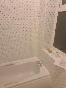 een witte badkamer met een wastafel en een raam bij ODF foundation apartments in Strood