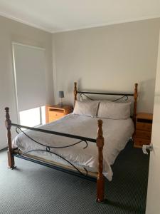 1 dormitorio con 1 cama con marco de madera en Peterborough Getaway en Peterborough