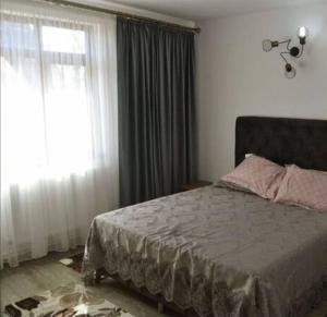 a bedroom with a bed and a large window at Lotca lu Vasile in Crisan