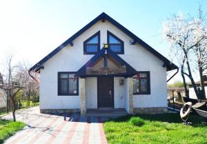 a small white house with a cross on the front at Lotca lu Vasile in Crisan +1 photo
