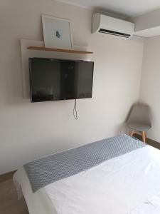 a bedroom with a bed and a tv on the wall at Studio Bohemio in Lima