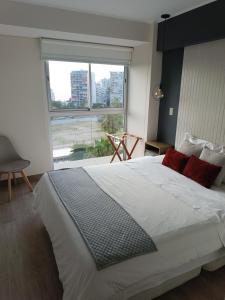 a bedroom with a large bed with a large window at Studio Bohemio in Lima