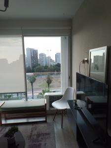 a living room with a large window and a couch at Studio Bohemio in Lima