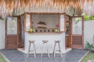 a bar with two stools in front of a building at Oasis Bungalows in Uluwatu