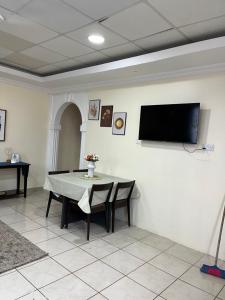 uma sala de jantar com uma mesa e uma televisão de ecrã plano em Mikocheni smart space em Dar es Salaam
