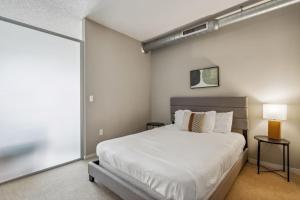 ein Schlafzimmer mit einem Bett und einem großen Fenster in der Unterkunft CozySuites 2BR Mill District pool gym # 02 in Minneapolis