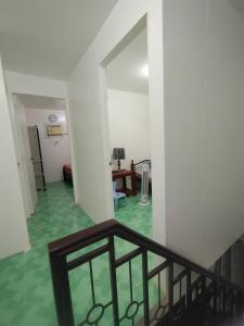 バコロドにあるDawn's Suite Homeの緑の床と階段のある廊下の景色を望めます。