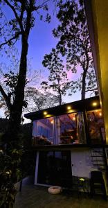 ein Haus mit einem großen Fenster und einem Baum in der Unterkunft LA CABAÑA & hiking in Jacó