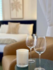 two wine glasses sitting on a table next to a couch at Luxe Palm Studio Villa - In the heart of Edge Hill in Edge Hill