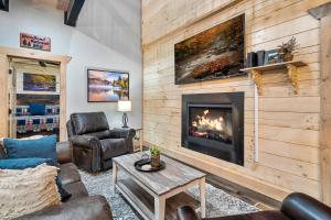 a living room with a fireplace and leather furniture at New Luxury Vacation Home Cabin in Smoky Gatlinburg - Theater Room in Gatlinburg
