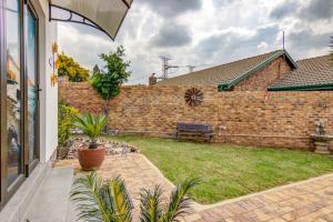 un mur en briques avec un banc dans une cour dans l'établissement Lavender Villa No loadshedding, à Kempton Park