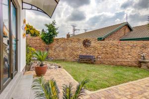a brick wall with a bench in a yard at Lavender Villa No loadshedding in Kempton Park