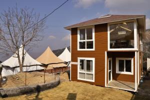 a house with a tent in front of it at MUSSOORIE ADVENTURE RESORT in Mussoorie