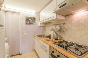 uma pequena cozinha com um fogão e um lavatório em Libeccio House - Happy Rentals em Avola