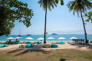 瑤亞島的住宿－Royal Yao Yai Island Beach Resort，沙滩上,有遮阳伞,有人坐在沙滩上