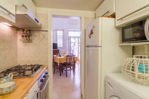 uma cozinha com um frigorífico branco e uma mesa em Libeccio House - Happy Rentals em Avola