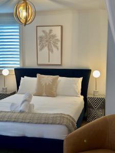 Un dormitorio con una cama con una palmera. en Luxe Palm Studio Villa - In the heart of Edge Hill en Edge Hill