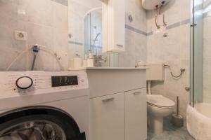 a washing machine in a bathroom with a toilet at Apartments Jagoda in Makarska