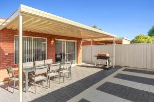 un patio con mesa, sillas y parrilla en Shamrock House C, en Renmark