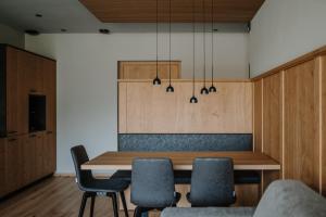 een eetkamer met een houten tafel en stoelen bij Stollhof - New 2024 in Lagundo