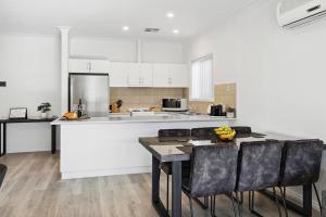 a kitchen with a table and chairs and a counter at Shamrock House C in Renmark