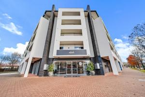 a large white building with a sign on it at Comfy Lakeside 1-Bed with Secure Parking in Tuggeranong