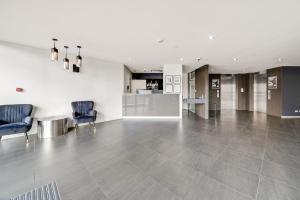 an empty lobby with two chairs and a counter at Comfy Lakeside 1-Bed with Secure Parking in Tuggeranong