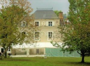 a large white house with a green fence at Le petit plessis in Ruaudin