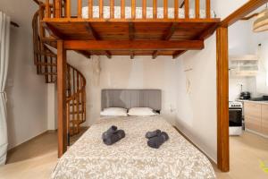 una camera da letto con un letto e due pantofole sopra di Dionysia Sea Side By Greece Apartment a Selianitika
