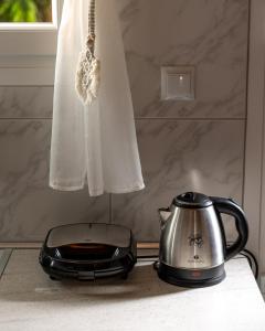 a tea kettle sitting on a counter next to a window at Dionysia Sea Side By Greece Apartments in Selianitika