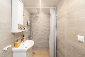 bagno con lavandino bianco e doccia di Dionysia Sea Side By Greece Apartment a Selianitika