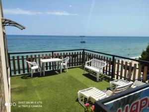 a balcony with chairs and tables and the ocean at Happy Beach Rooms in Varna City