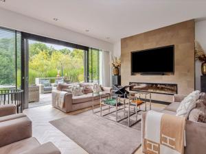 ein Wohnzimmer mit einem Kamin und einem Flachbild-TV in der Unterkunft Wellness villa on the water near Harderwijk in Zeewolde