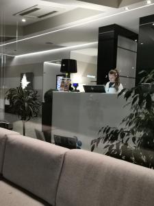 une femme se tenant derrière un comptoir dans un bureau dans l'établissement Best Western Plus Hotel Modena Resort, à Formigine