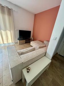 a living room with two beds and a flat screen tv at Appartement à 200m des plages. in Fréjus