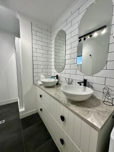 uma casa de banho com 2 lavatórios e um espelho grande em Luxe Palm Studio Villa - In the heart of Edge Hill em Edge Hill
