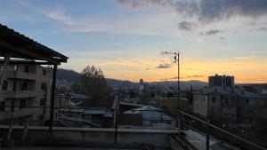 a view of a city with the sunset in the background at Garden House Tbilisi in Tbilisi City