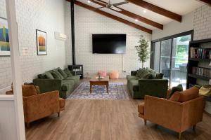 uma sala de estar com sofás e uma televisão de ecrã plano em The Bright Resort em Bright