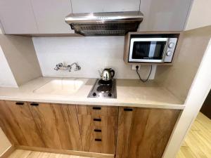 a small kitchen with a sink and a microwave at Ny Suites in Beirut